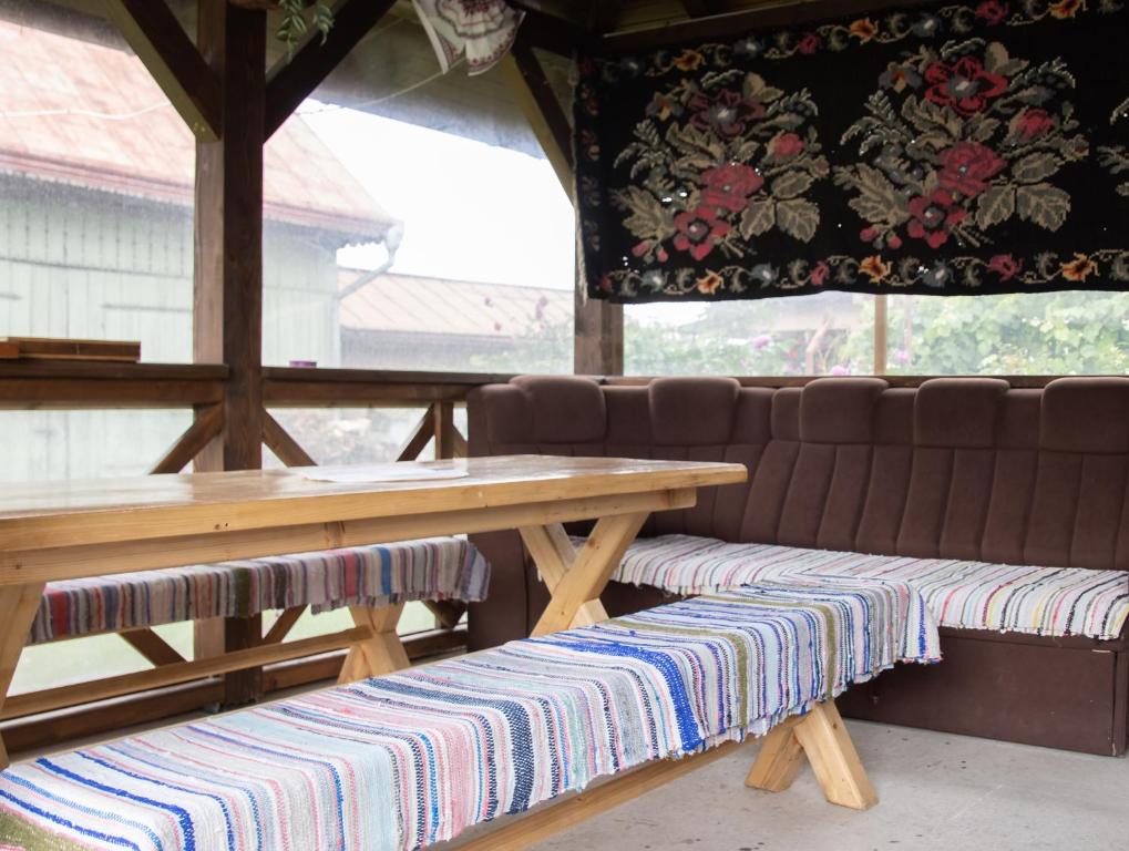 a picnic table and bench with a table and a curtain at Casuta bunicilor in Volovăţ