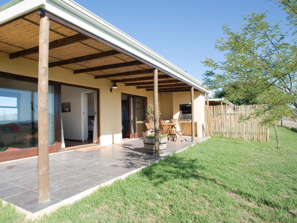 a house with a patio and a fence at Wild Clover Cottages in Stellenbosch