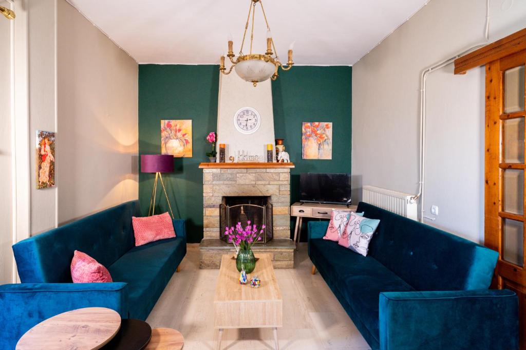 a living room with blue couches and a fireplace at Ilia house in Volos