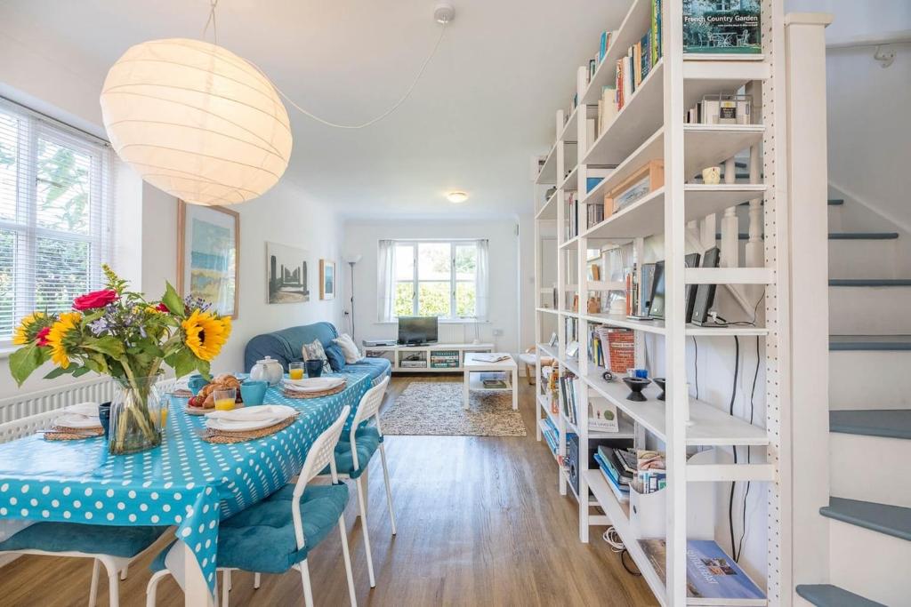 a living room with a table and a book shelf at Chestnutt Cottage, Reydon in Reydon