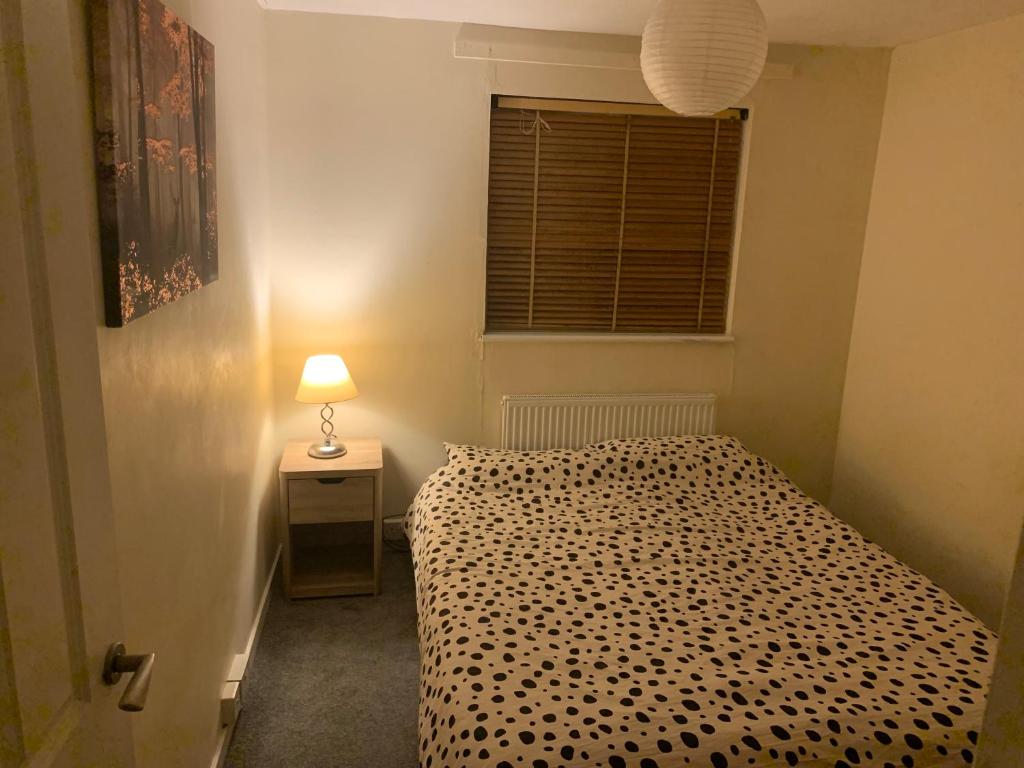 a bedroom with a bed and a lamp and a window at Double room Eastbourne in Polegate