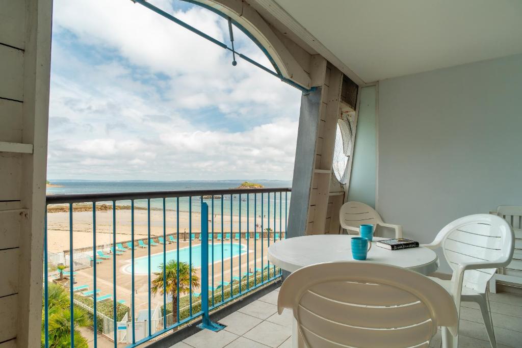 einen Balkon mit einem Tisch und Stühlen sowie Strandblick in der Unterkunft Le Tamm Bara - Appt avec piscine partagée in Douarnenez