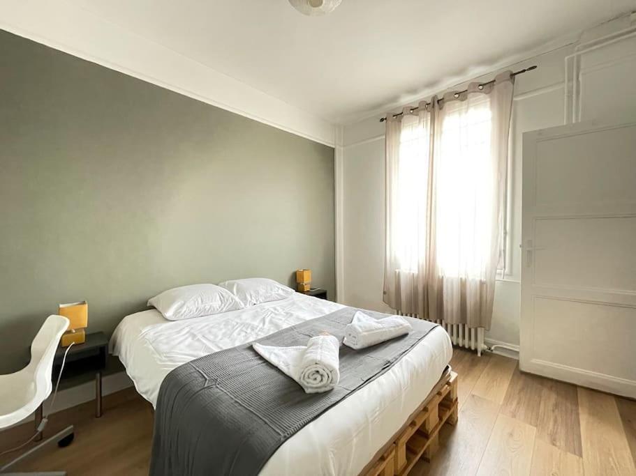 une chambre avec un grand lit et une fenêtre dans l'établissement Rouen Gare - Les Marronniers, à Rouen