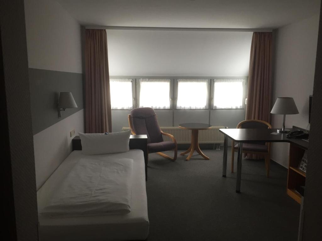a hotel room with a bed and a chair and a table at Business apartment in 3 star hotel Daimler Nah in Sindelfingen