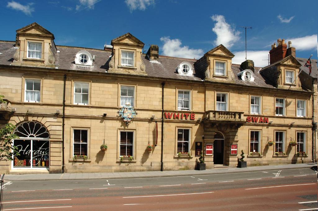 um grande edifício de pedra ao lado de uma rua em White Swan Hotel em Alnwick