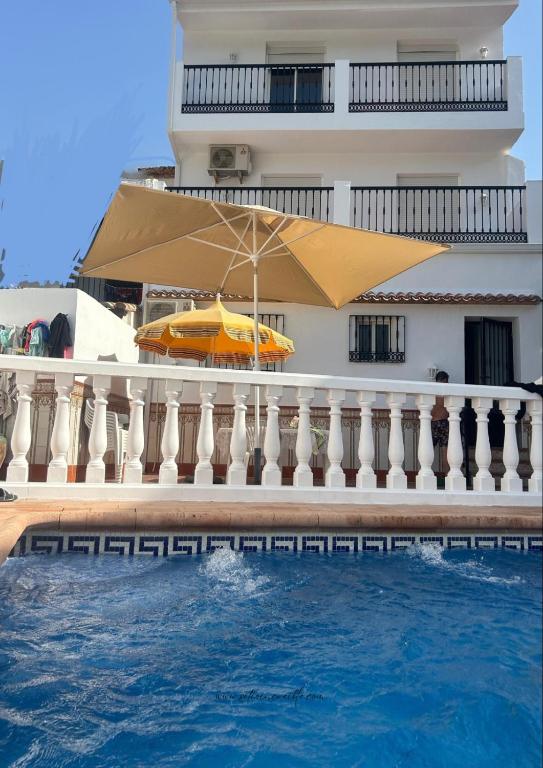 a building with an umbrella next to a swimming pool at El Siprer in Anna