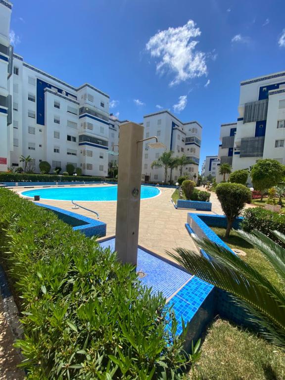 a swimming pool in front of some buildings at appartement pour vacances avec piscine in Bouznika