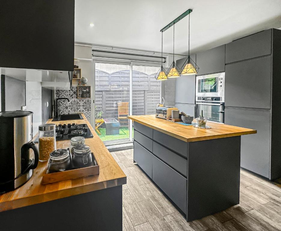 une cuisine avec une cuisinière et un comptoir dans l'établissement La Maison des Saisons - Paris - La Défense ARENA, à Carrières-sur-Seine