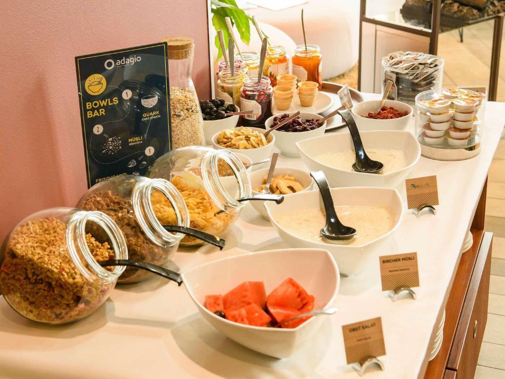 a buffet with bowls of food on a table at Aparthotel Adagio Muenchen City in Munich
