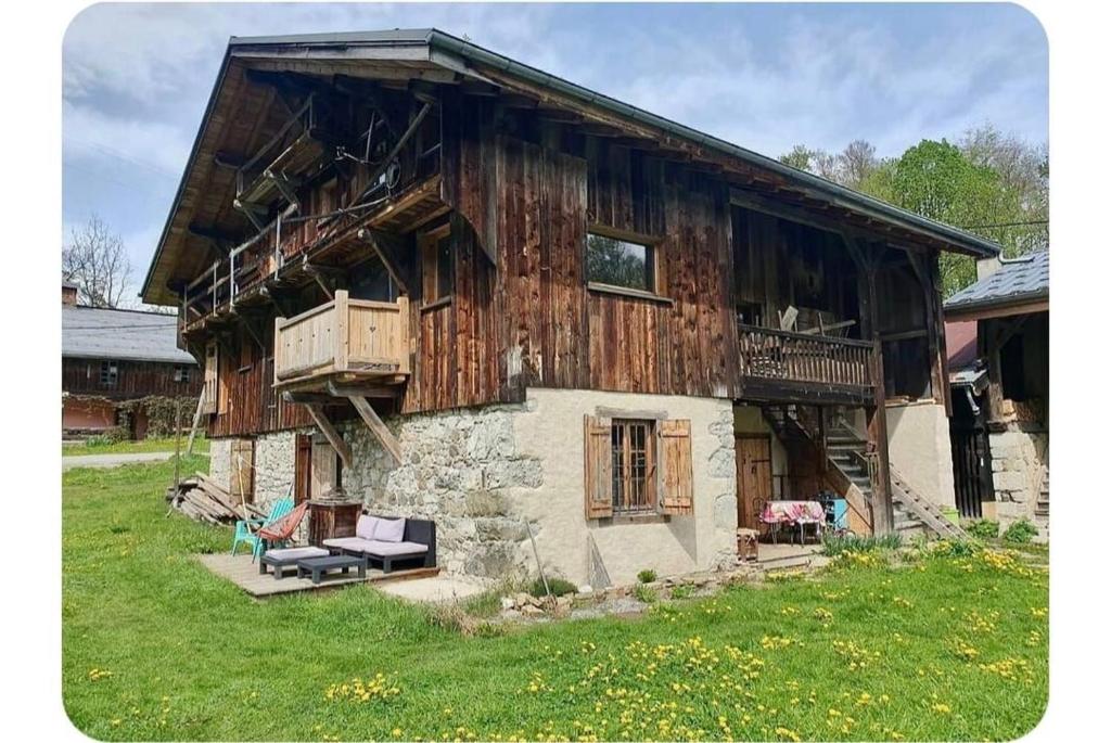 une vieille maison en bois avec un banc devant elle dans l'établissement Chalet Combe, à Samoëns