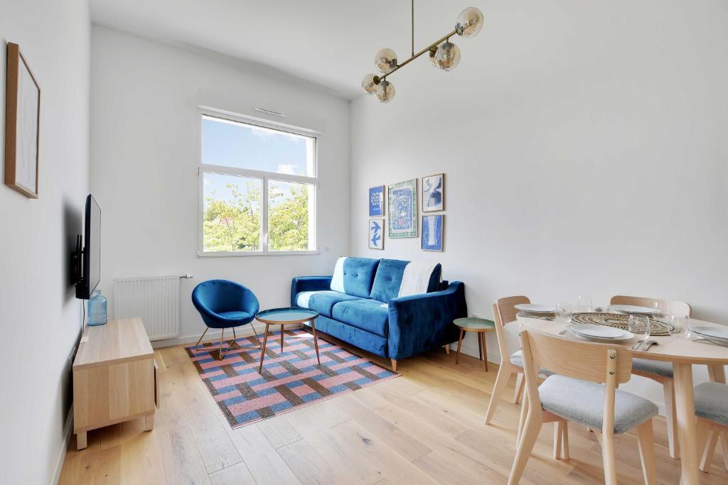 un salon avec un canapé bleu et une table dans l'établissement Charming Apartment -2BR-6P- Nogent-sur-Marne, à Nogent-sur-Marne