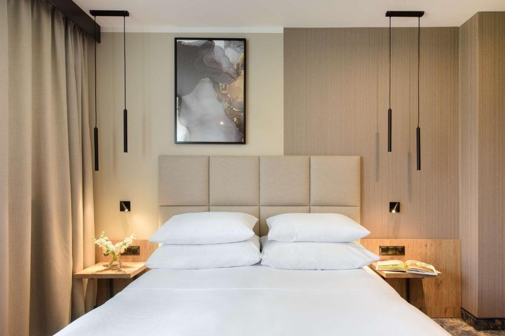 ein Schlafzimmer mit einem großen Bett mit weißen Kissen in der Unterkunft Best Western Plus Hotel Olsztyn Old Town in Olsztyn