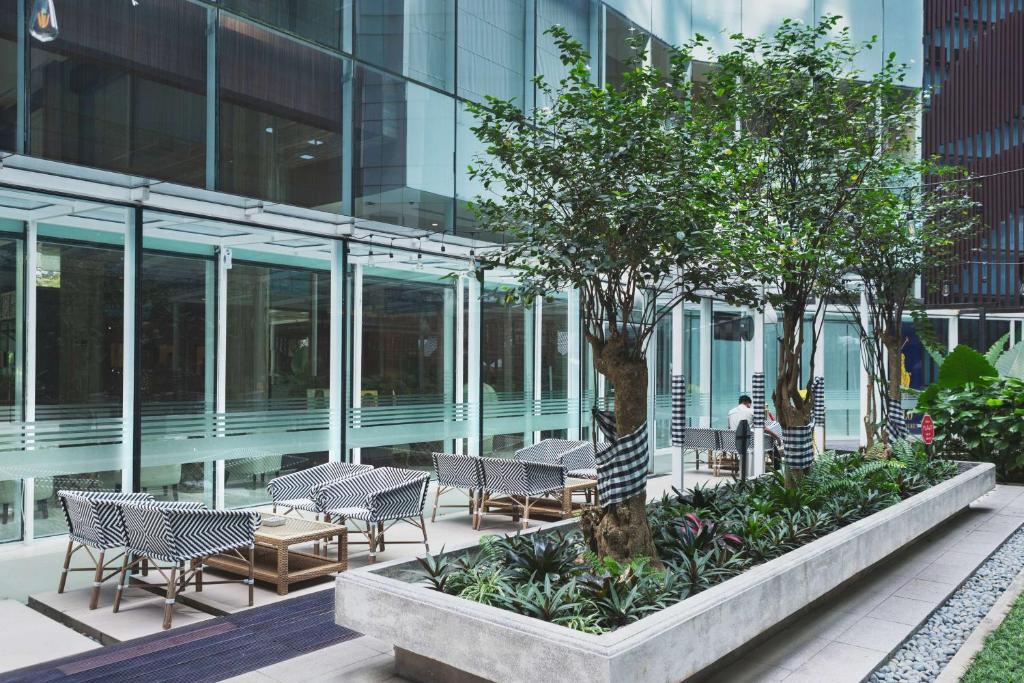 a courtyard with chairs and trees in a building at Wyndham Panbil Batam in Batam Center