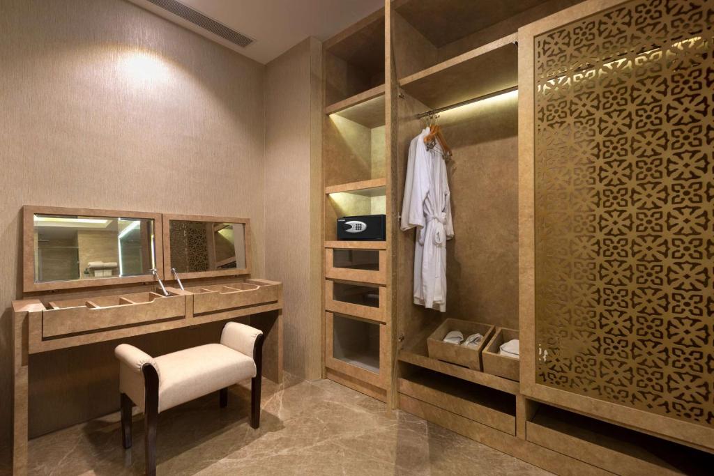 a dressing room with a vanity and a mirror at Wyndham Panbil Batam in Batam Center
