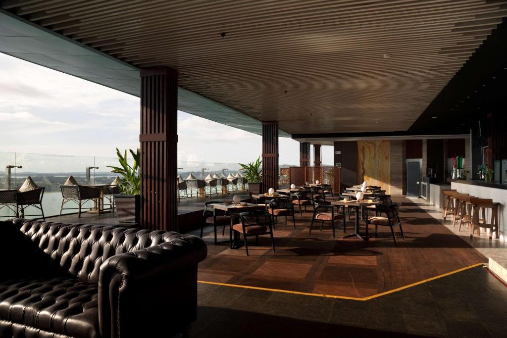 a restaurant with a leather couch and tables and chairs at Wyndham Panbil Batam in Batam Center