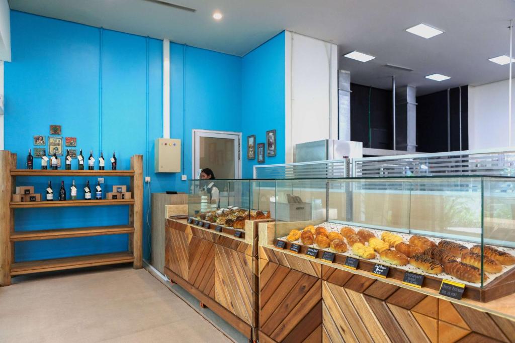 a bakery with blue walls and a display case with pastries at Wyndham Panbil Batam in Batam Center