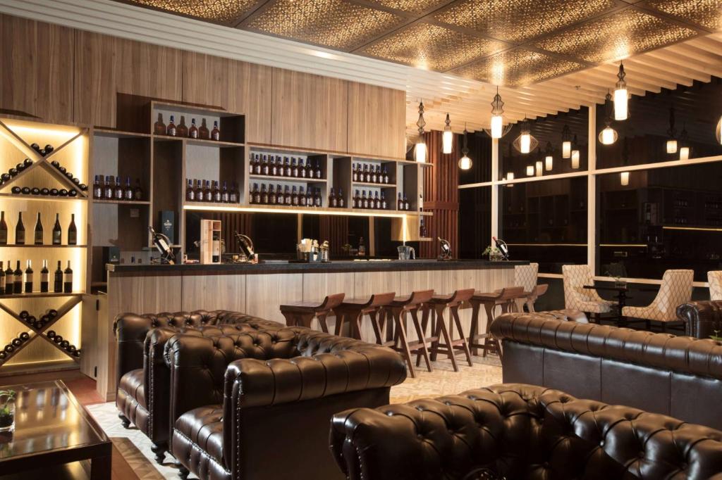 a bar with brown leather seats in a room at Wyndham Panbil Batam in Batam Center