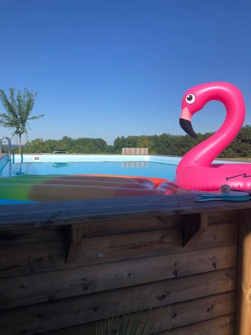 un jouet rose flamant assis au-dessus d'une clôture dans l'établissement Villa dans le Périgord, à Couze-et-Saint-Front