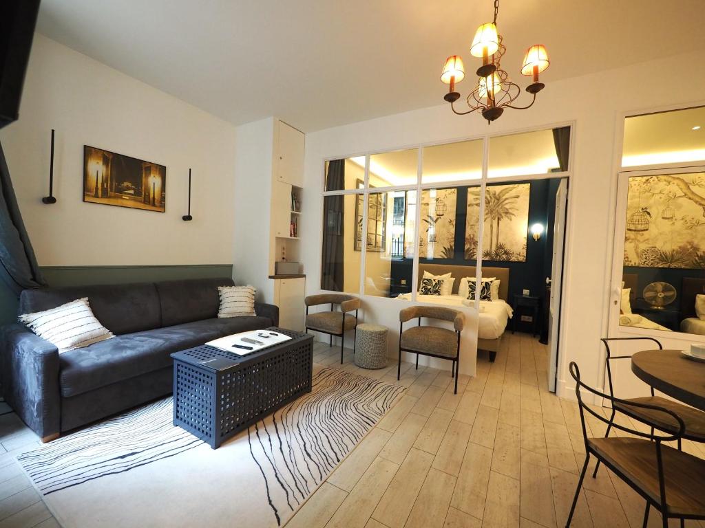 un salon avec un canapé et une table dans l'établissement Saint Germain Elegant ChicSuites, à Paris