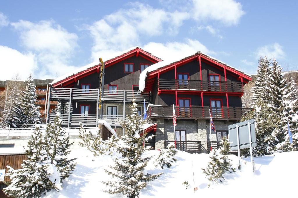 a large red building in the snow with trees at Hotel Biancaneve in Sestriere