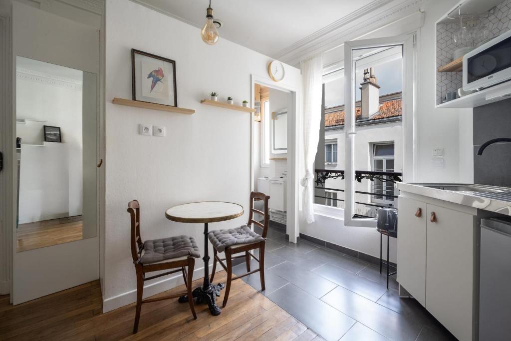 Una cocina con una mesa y sillas en una habitación. en Studio Ginoux - Welkeys, en Montrouge