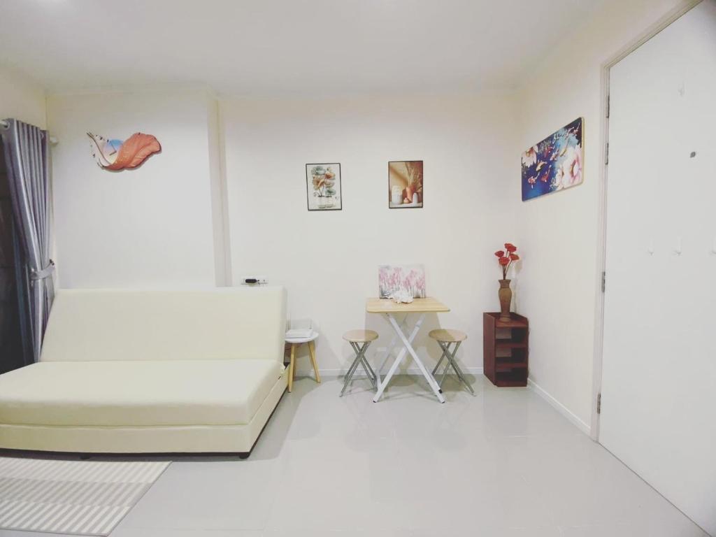 a white room with a bed and a table at 1 Bedroom Seaview Jomtein Pattaya 33sqm floor9th 90 3 in Jomtien Beach