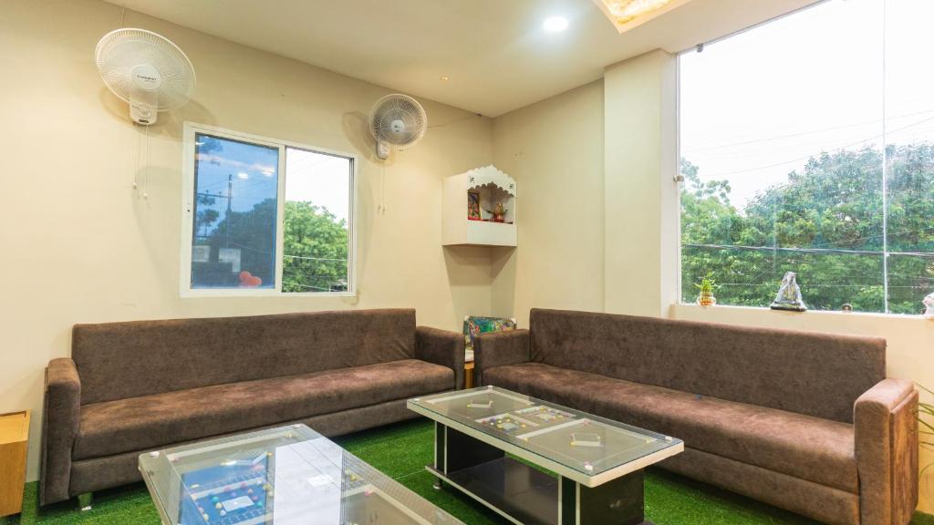 a living room with two couches and a table at Hotel Mahakal Avantika Palace in Ujjain