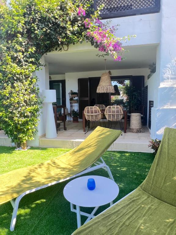 a patio with a yellow hammock and a table at La Alcaidesa Valerie & Bruno in San Roque