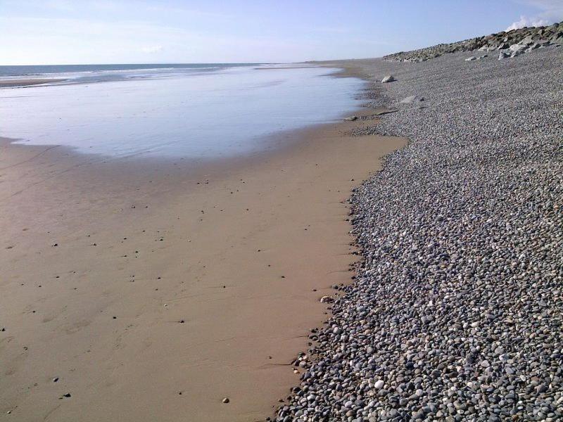 una spiaggia con costa rocciosa e l'oceano di Premier Caravan 253 at Neptune Park a Tywyn
