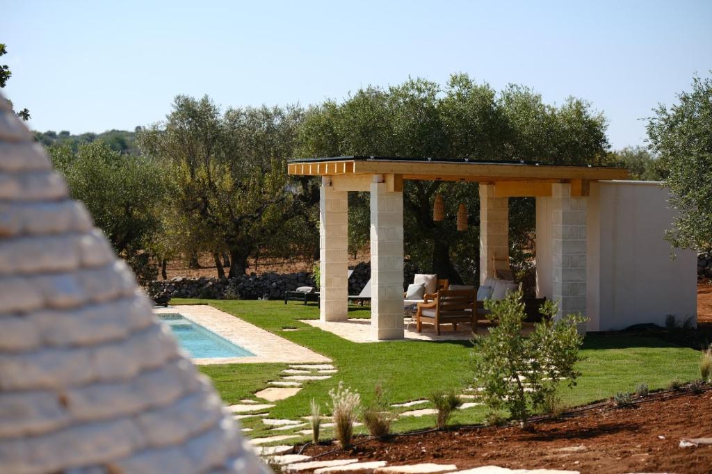 - un kiosque dans une cour à côté d'une piscine dans l'établissement Borgo dei trulli Fanelli, à Castellana Grotte 55 autres photos
