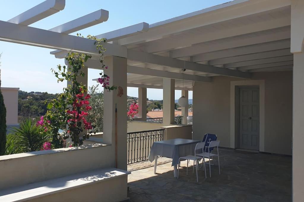 a patio with a table and chairs on a balcony at Studio Villa Emeli, close to beaches and downtown in Porto Heli