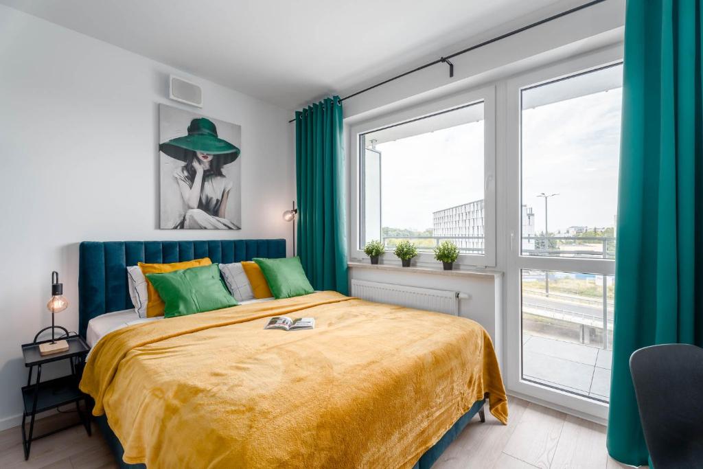 een slaapkamer met een bed en een groot raam bij Chill Apartments Pileckiego in Warschau