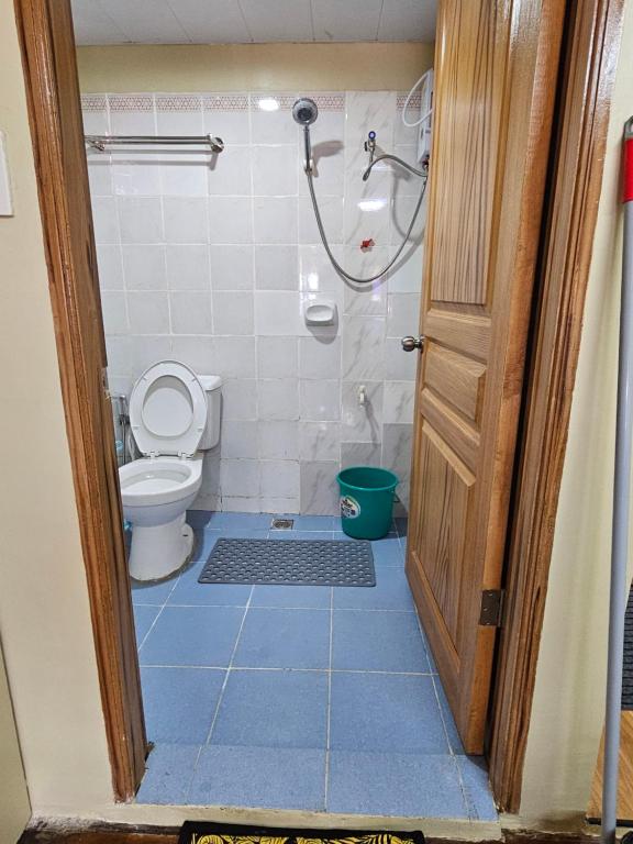 a bathroom with a shower and a toilet and a door at The Catolico's 2 bedroom Transient in Baguio