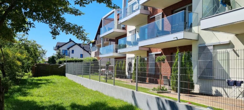 an apartment building with a fence in front of it at Villa Szyprów in Jastarnia