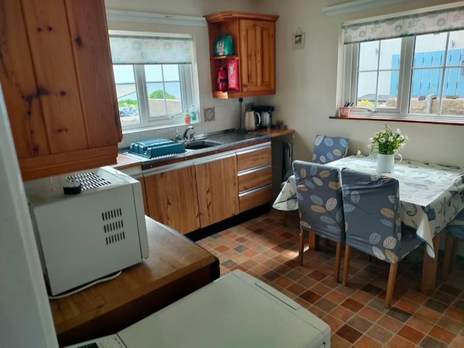a kitchen with a table and a dining room at The Beach House Annalong Cosy beachview cottage in Annalong