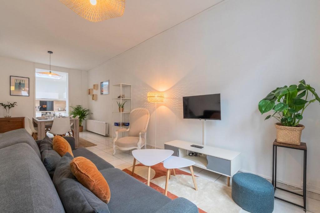 ein Wohnzimmer mit Sofa und Fernseher in der Unterkunft Maison 3 chambres rénovée, proche centre-ville in Marcq-en-Baroeul