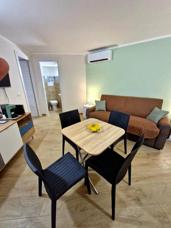 a living room with a table and chairs and a couch at Medea in Syracuse