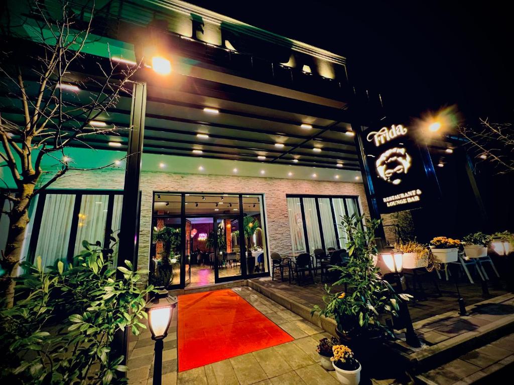 un edificio con una alfombra roja delante de él en Hotel &amp; Restaurant Frida, en Gjakove