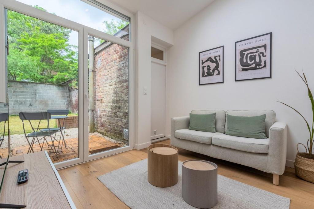 un salon avec un canapé et une table dans l'établissement Appartement une chambre avec jardin, proche tram, à Tourcoing