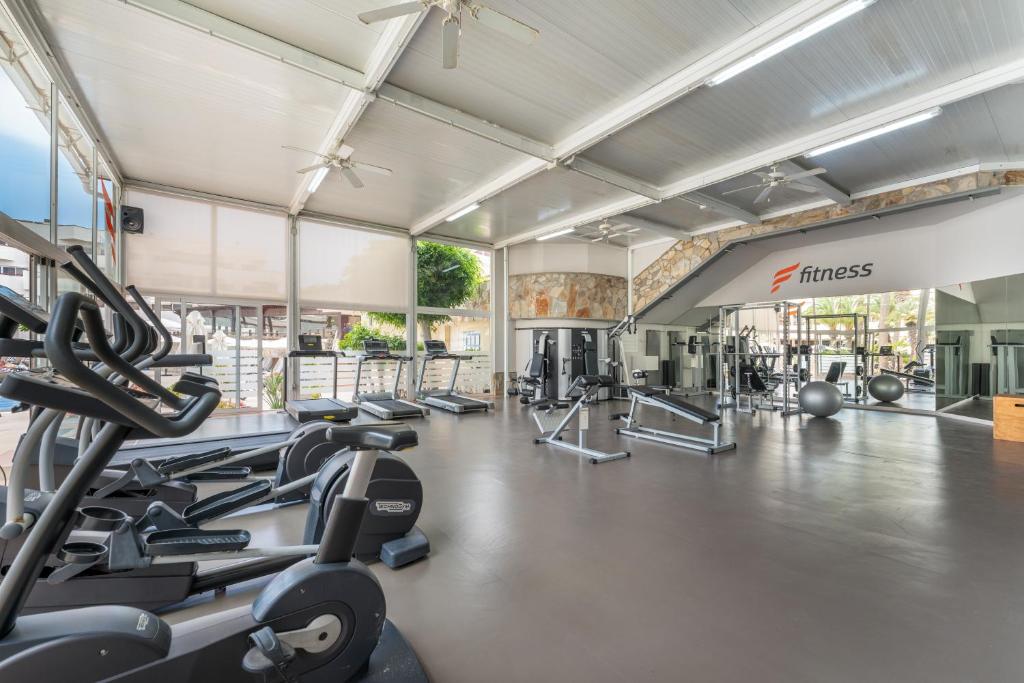 a gym with treadmills and elliptical machines at Barceló Corralejo Bay - Adults Only in Corralejo