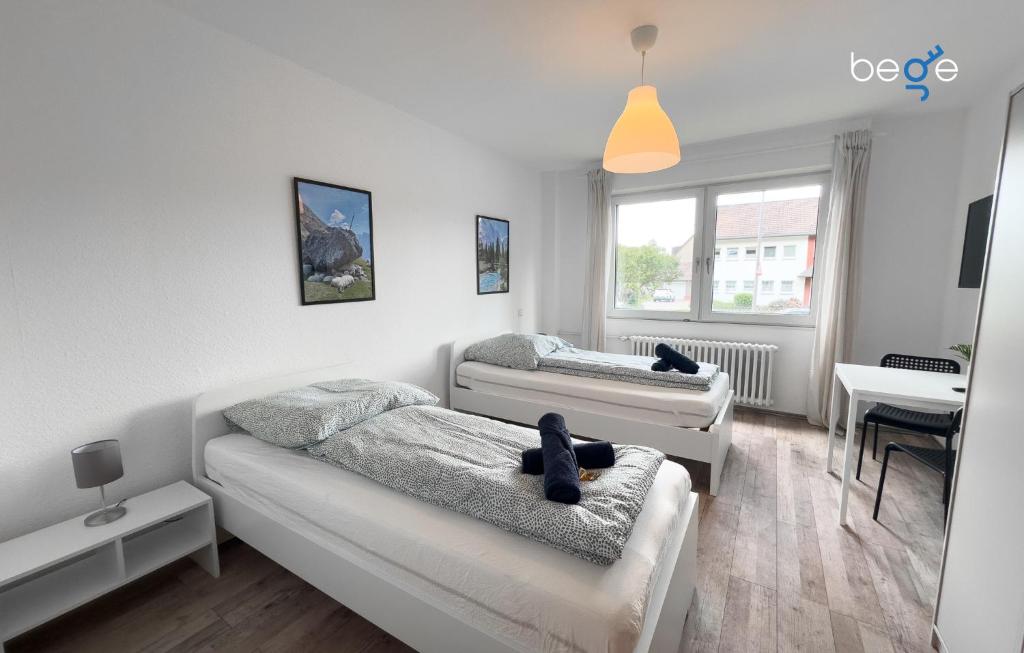 ein Wohnzimmer mit zwei Betten und einem Tisch in der Unterkunft BEGE APARTMENTS Corporate Lodge in Gelsenkirchen