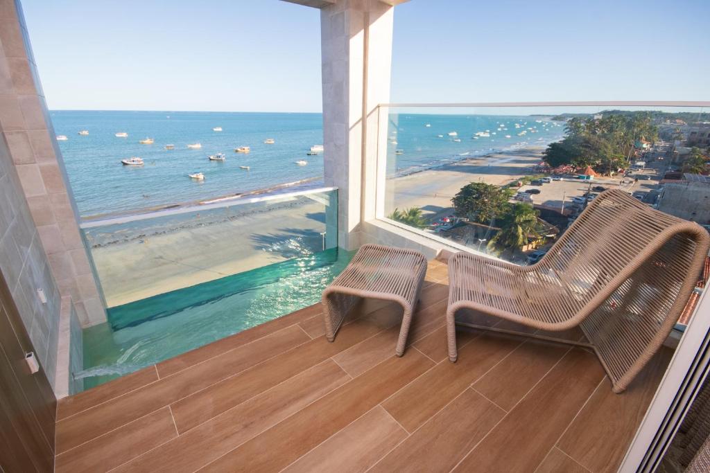 a balcony with two chairs and a view of the ocean at JANGA HOTEL BOUTIQUE in Maragogi