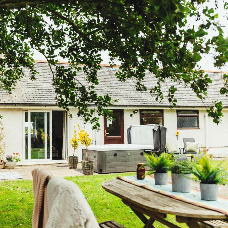 a backyard with a barbecue grill in a yard at Birchwood Cottage with hot tub in Valley