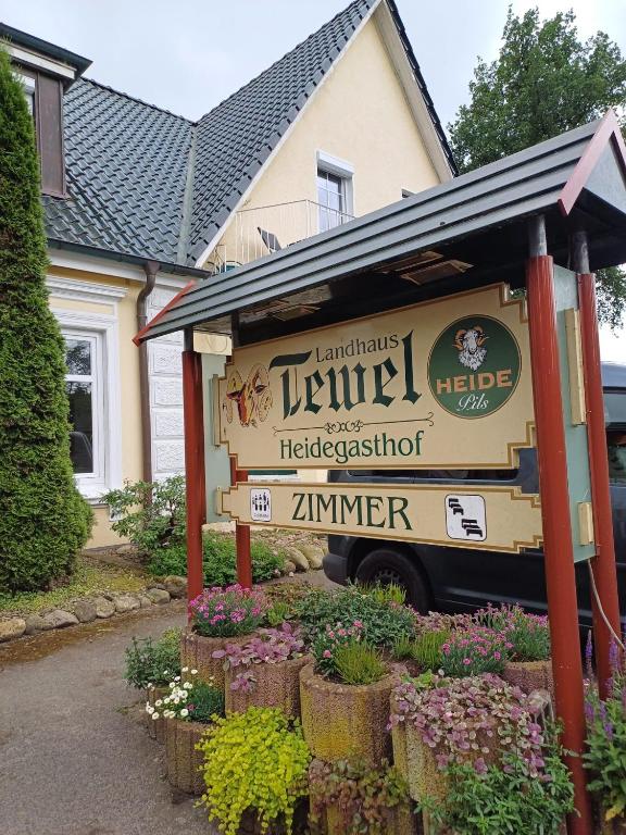 a sign for a restaurant in front of a house at Landhaus Tewel Hotel mit Restaurant 14KM vom Heide-Park in Tewel