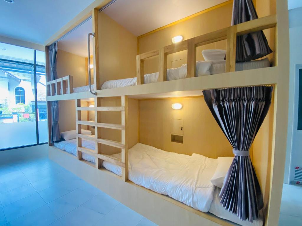 a bedroom with bunk beds with a window at MellowDee Female Hostel เมลโลดี โฮสเทลหญิง 女旅社 in Ban Kohong