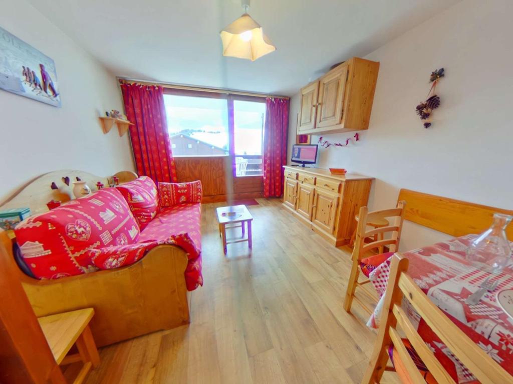 Il comprend un salon avec un canapé et un lit ainsi qu'une cuisine. dans l'établissement Studio cabine avec alcôve pour 4 aux Saisies, balcon au sud - FR-1-594-162, à Hauteluce