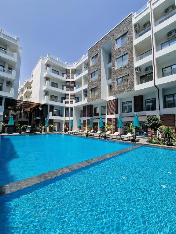 a swimming pool in front of some apartment buildings at 3BR 2BA Retreat with Four Pools Gym and Onsite Dining Close to El Gouna in Hurghada
