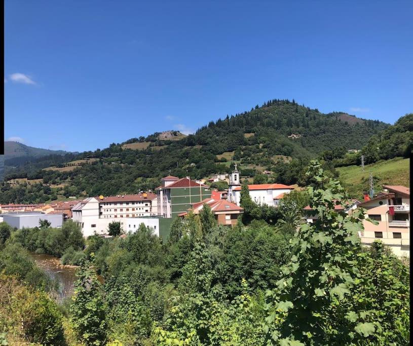 a group of buildings on a hill next to a mountain at La Casina Del Alce in Aller