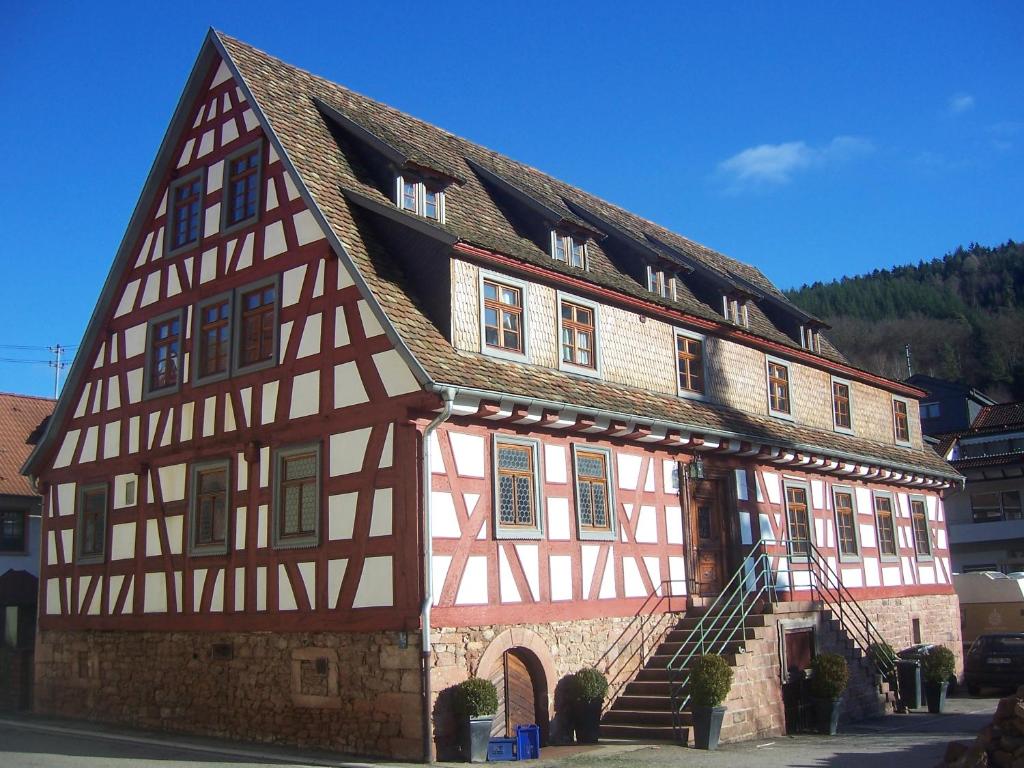 ein altes Haus mit einem braunen und weißen Gebäude in der Unterkunft Roter Löwe in Heiligkreuzsteinach