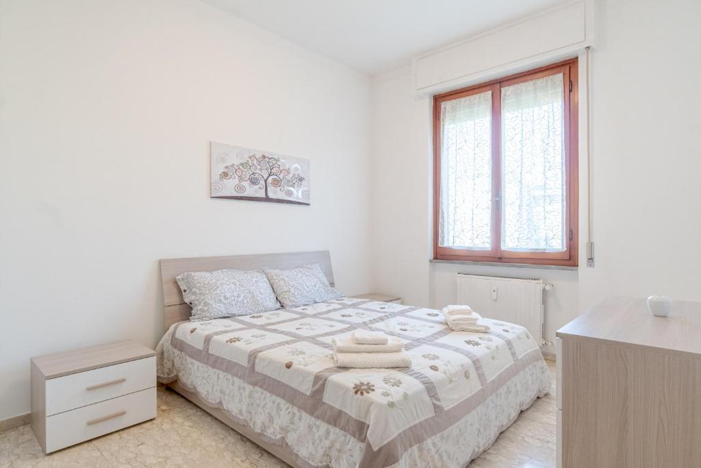 a white bedroom with a bed and a window at Mare e Monti a due Passi dalla Spiaggia! Ligurian Vacation Apartment in Chiavari